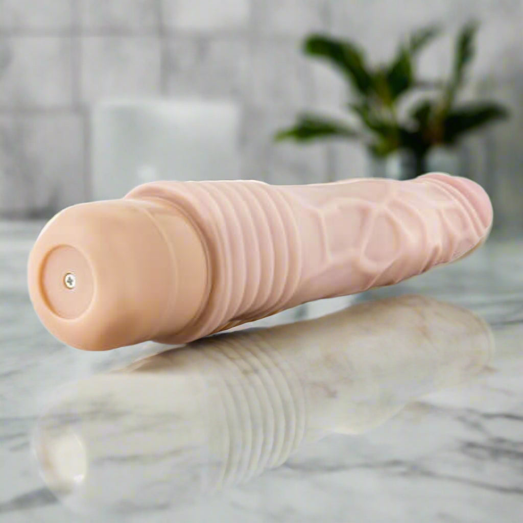 Beige vibrator with textured surface on a white background