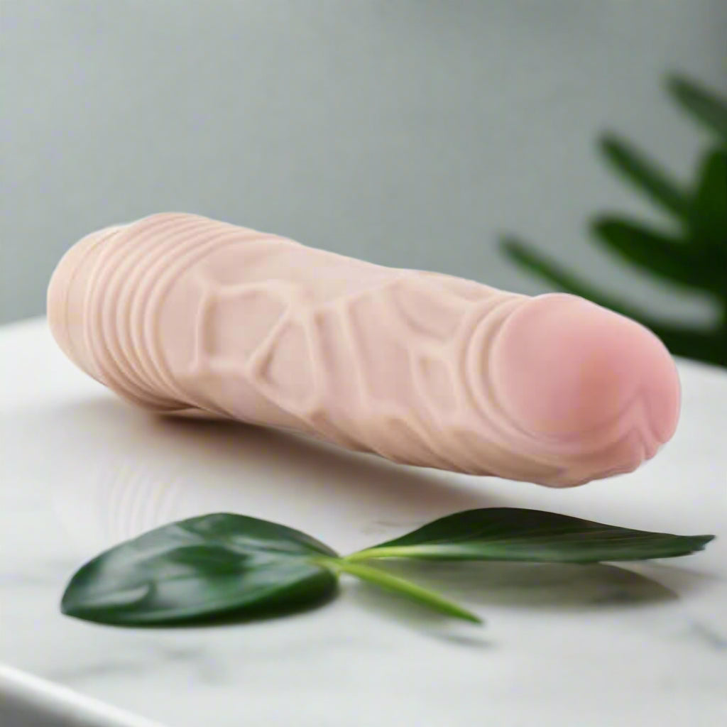 Realistic silicone vibrator on a white background