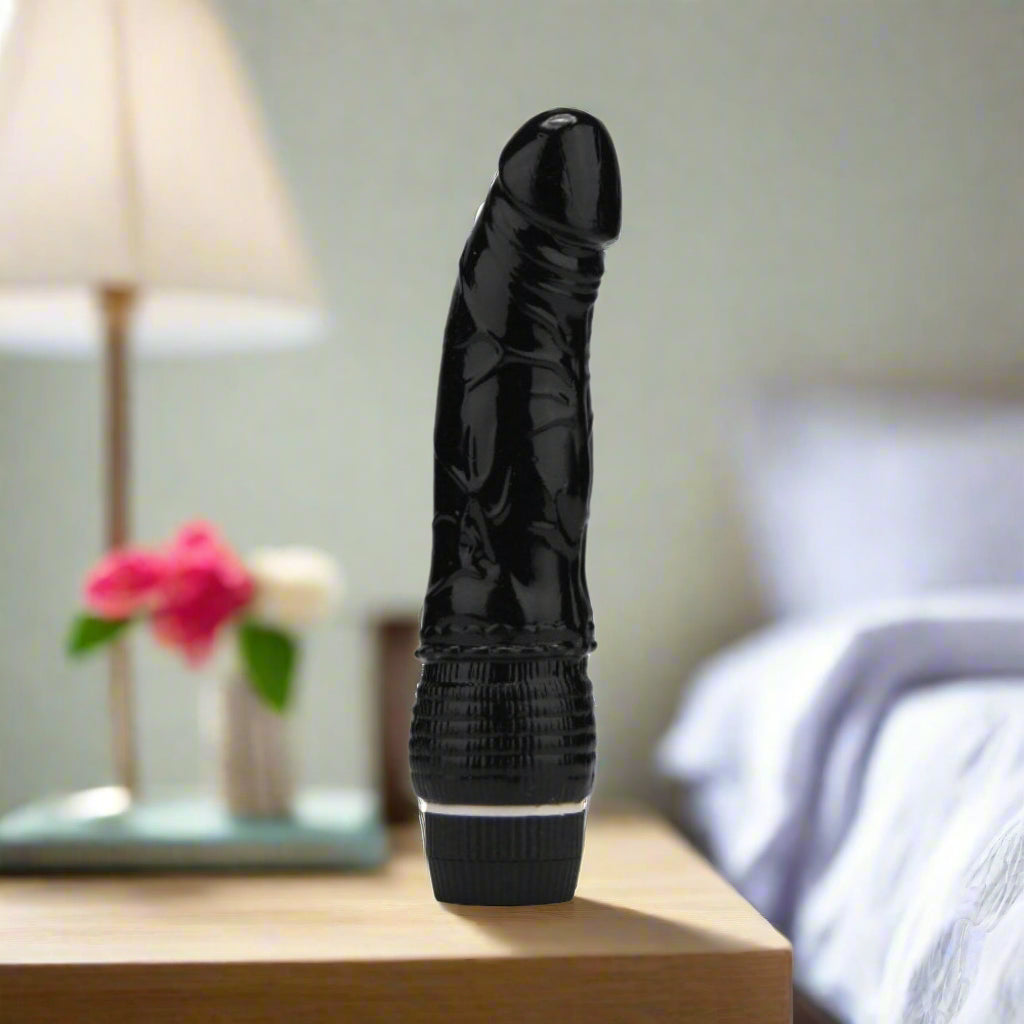 Black silicone vibrator on a white background