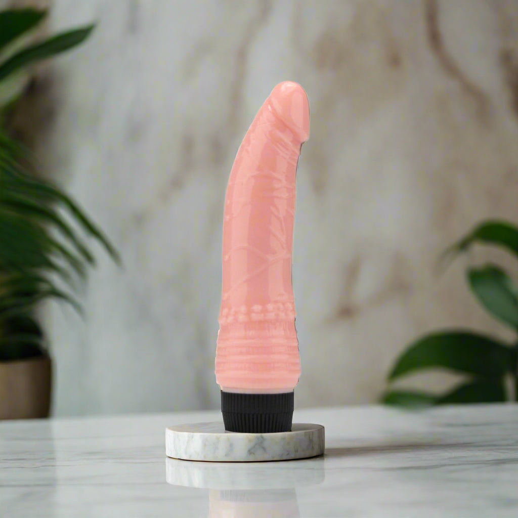 Pink silicone vibrator with black base on a white background