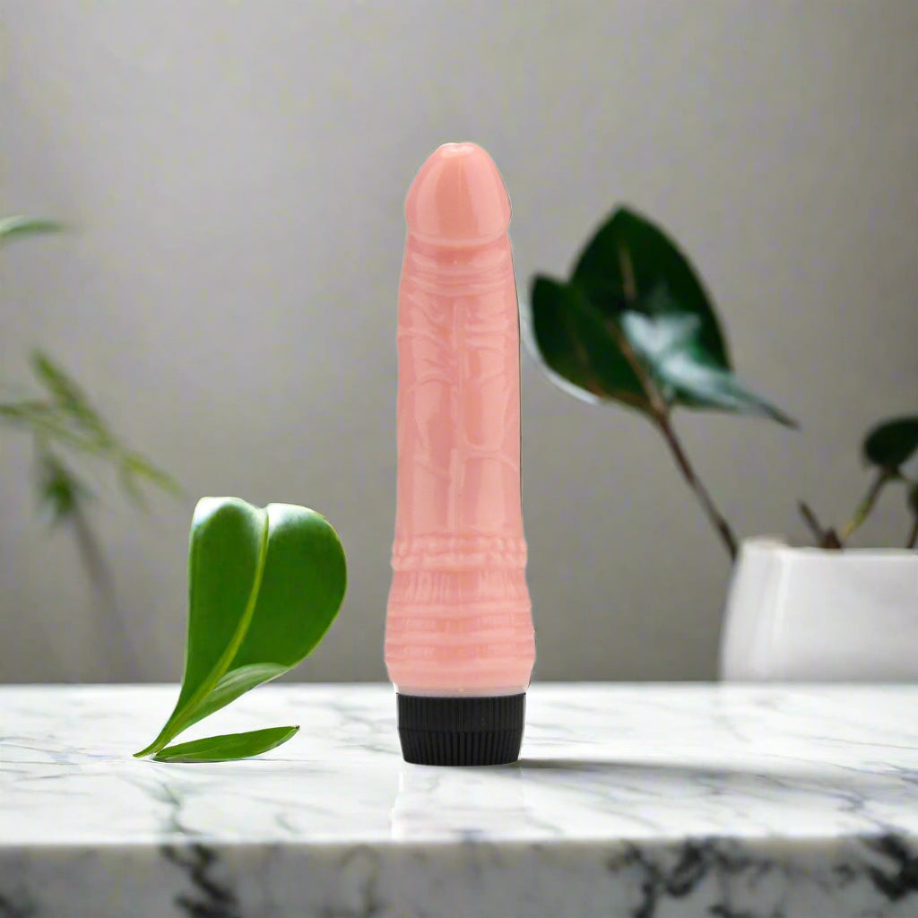 Pink silicone vibrator with black base on a white background