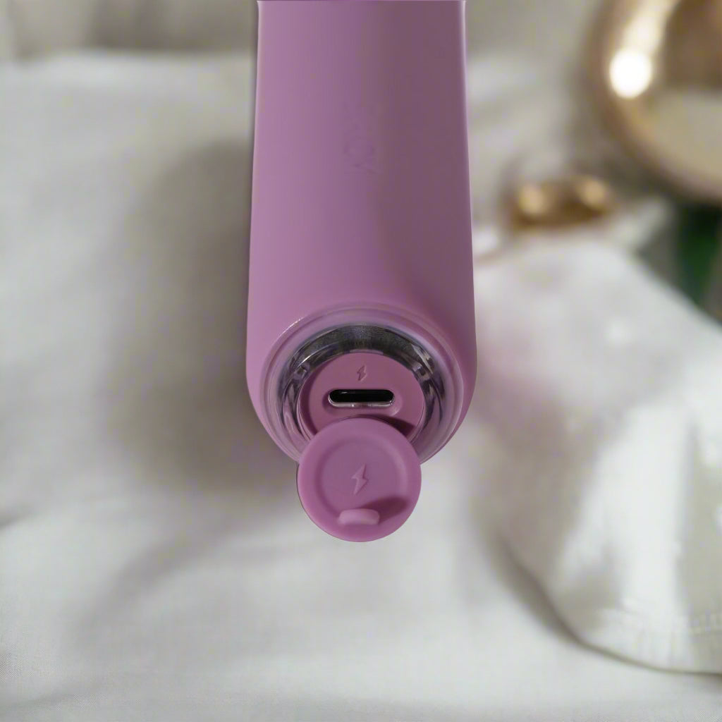 Close-up of a purple electronic device with charging port on a white background