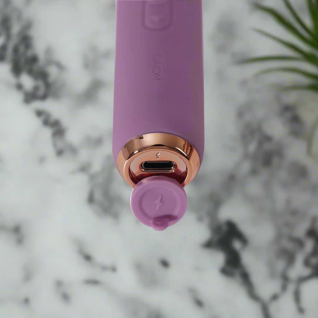 Purple electronic device with charging port on a white background