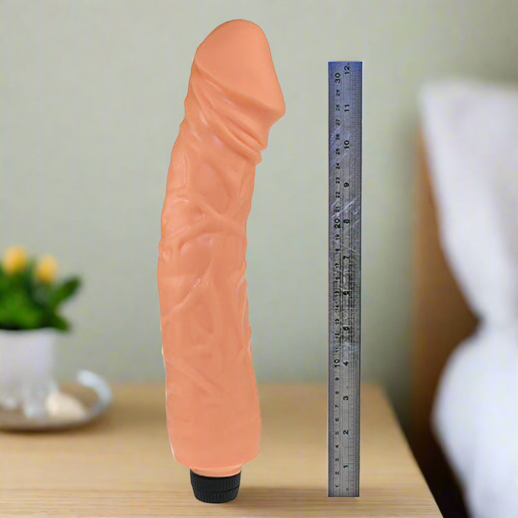 Silicone Vibrator with a ruler for scale on a white background